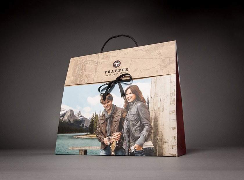 Paper gift bag with cover flap and bow, TRAPPER motif
